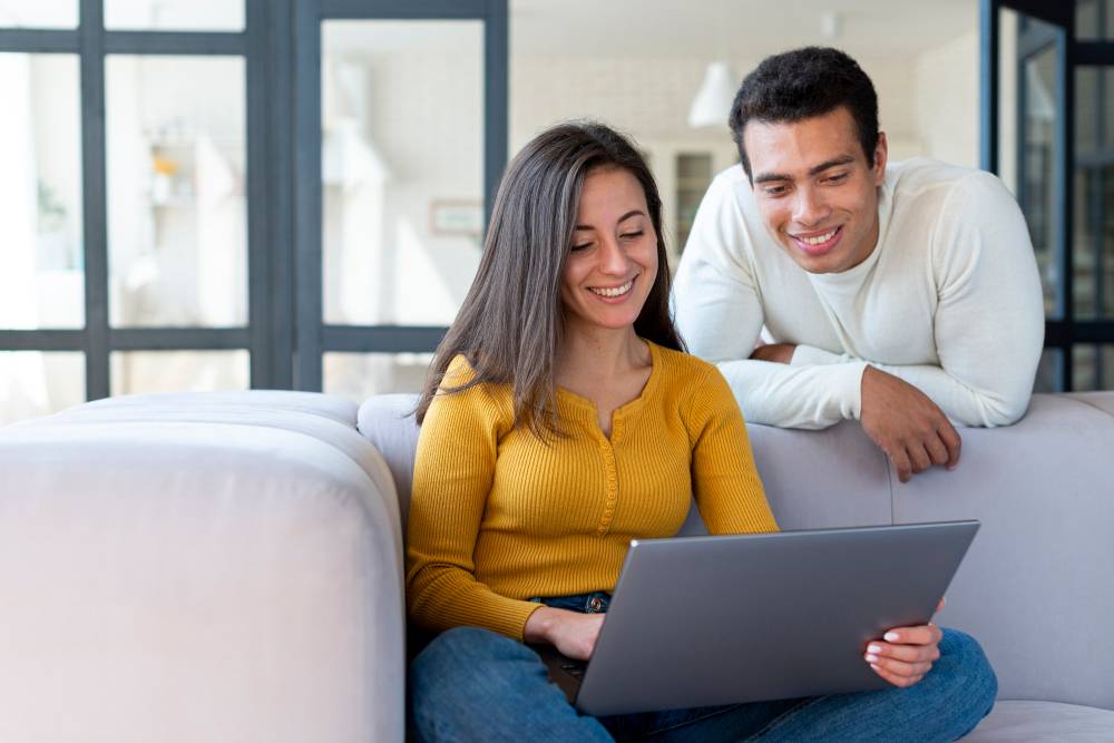 Medium shot of couple looking at laptop Medium shot of couple looking at laptop