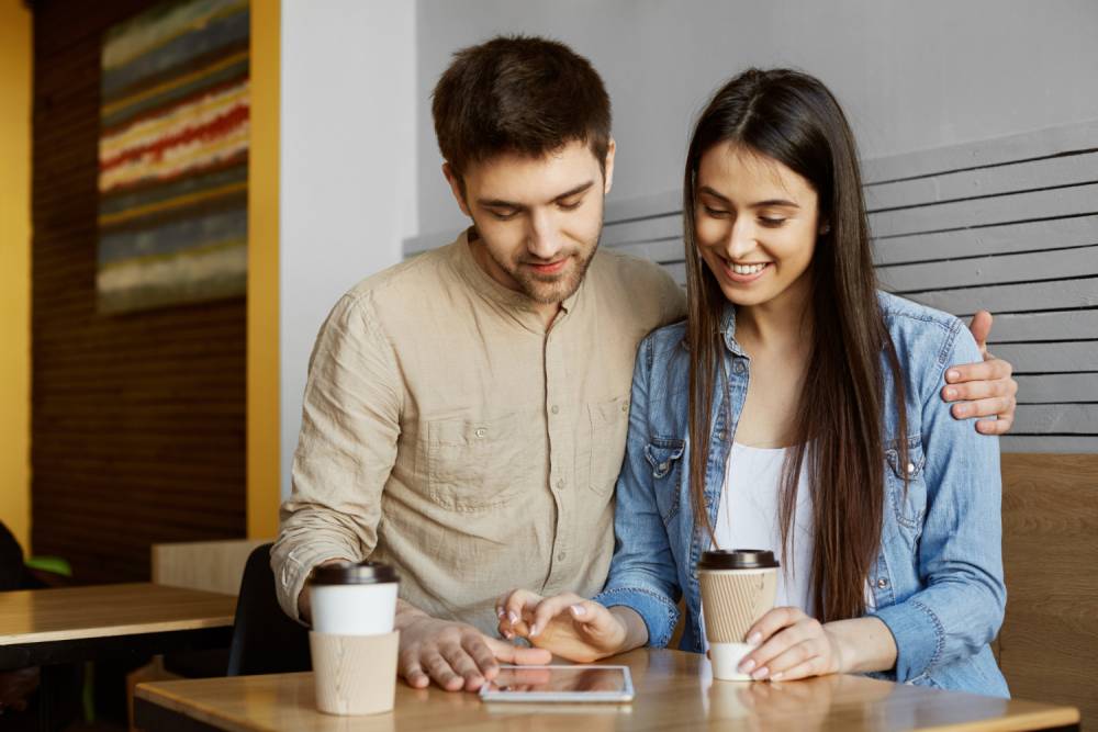Portrait of happy pair of young people sitting in cafeteria Portrait of happy pair of young people sitting in cafeteria